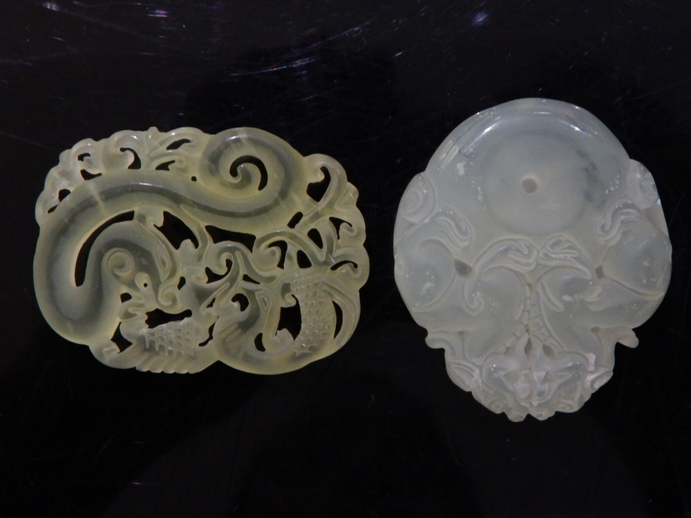 Two chinese jade pendants of dragons one with foliate carving, the other with two dragons around