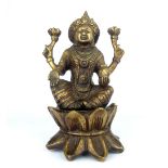 South East Asian bronzed figurine of seated deity on lotus base, 20cm h.