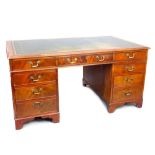 George III style mahogany pedestal desk, the tooled leather inset top above an arrangement of nine