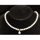 Strand of natural pearls with central drop and 14ct yellow gold clasp