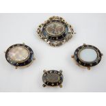 ''In memory of'', black enamel brooches, opaline and mother-of-pearl centres, the largest 6cm w.