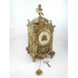 French late 19th C mantel clock, brass cherub finial, all over floral decoration, cherub masks.