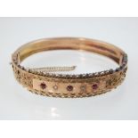 Edwardian ruby and diamond set 9ct yellow gold hinged bangle with engraved decoration 18.5 grs gross