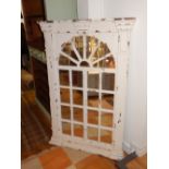 Distressed white painted frame wall mirror in the form of an arched window, 134cm h.