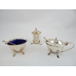 Three piece silver cruet set with spoons, blue glass liners, raised on paw feet,