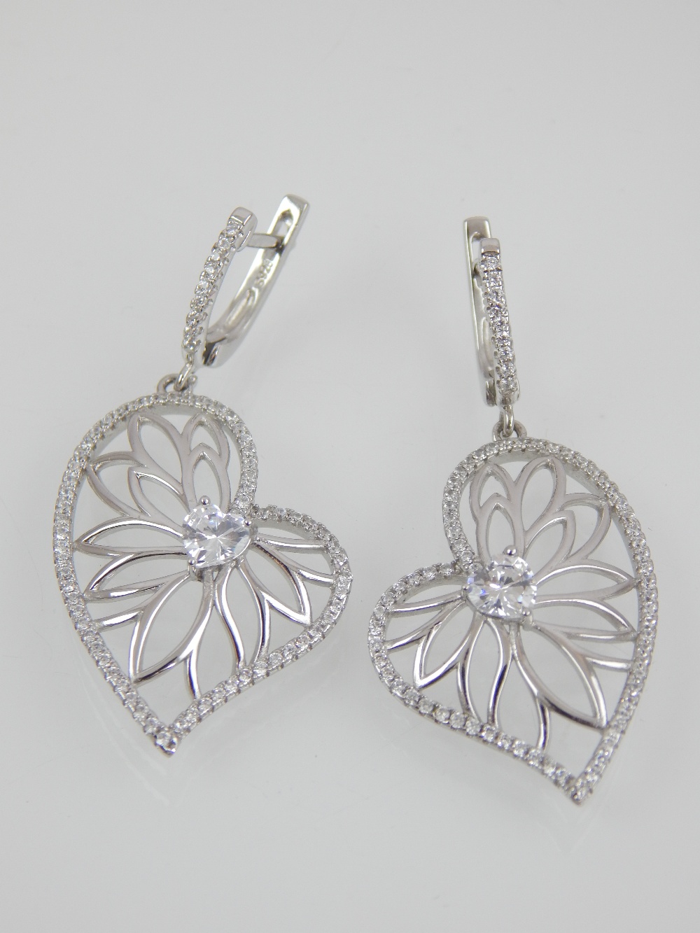 Pair of contemporary silver and white stone earrings of asymmetrical leaf form.