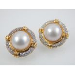 A pair of pearl and diamond earrings in yellow gold.