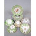 Eight 19th C porcelain dresser plates with hand-painted floral centres and green and gilt borders,