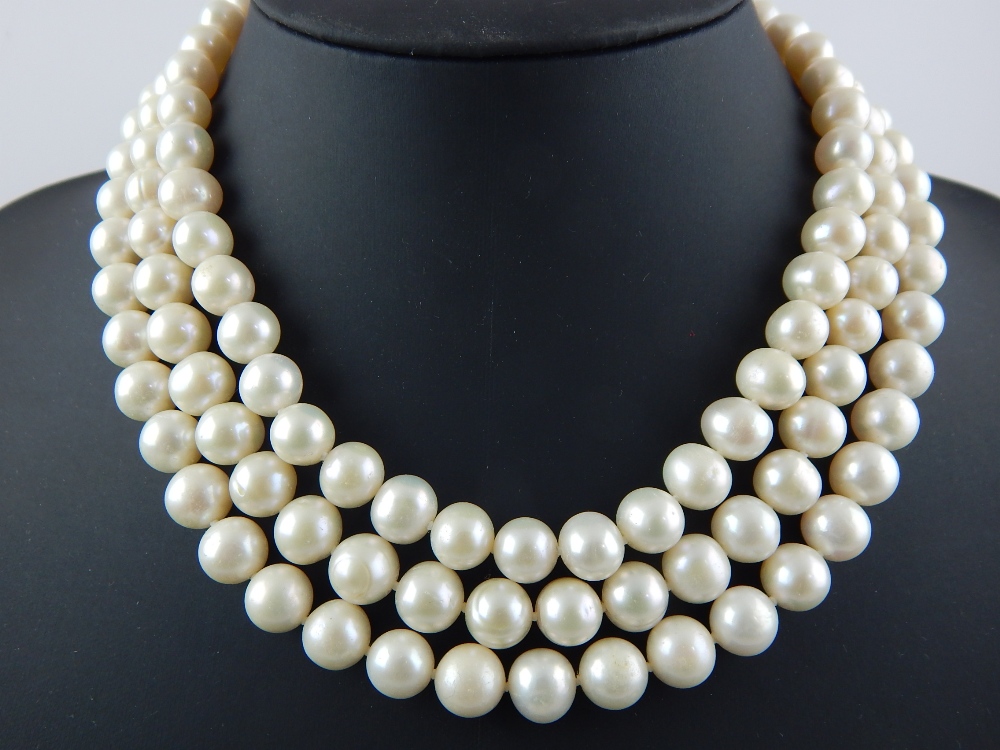 A three strand cultured pearl necklace with a gold clasp, the pearls, of an approx average of 9.