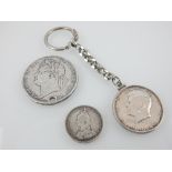 George IV silver crown coin dated 1821, a 1964 Kennedy half dollar mounted onto a key chain,
