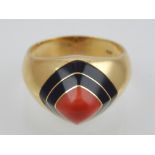A coral and black onyx ring set in yellow gold,