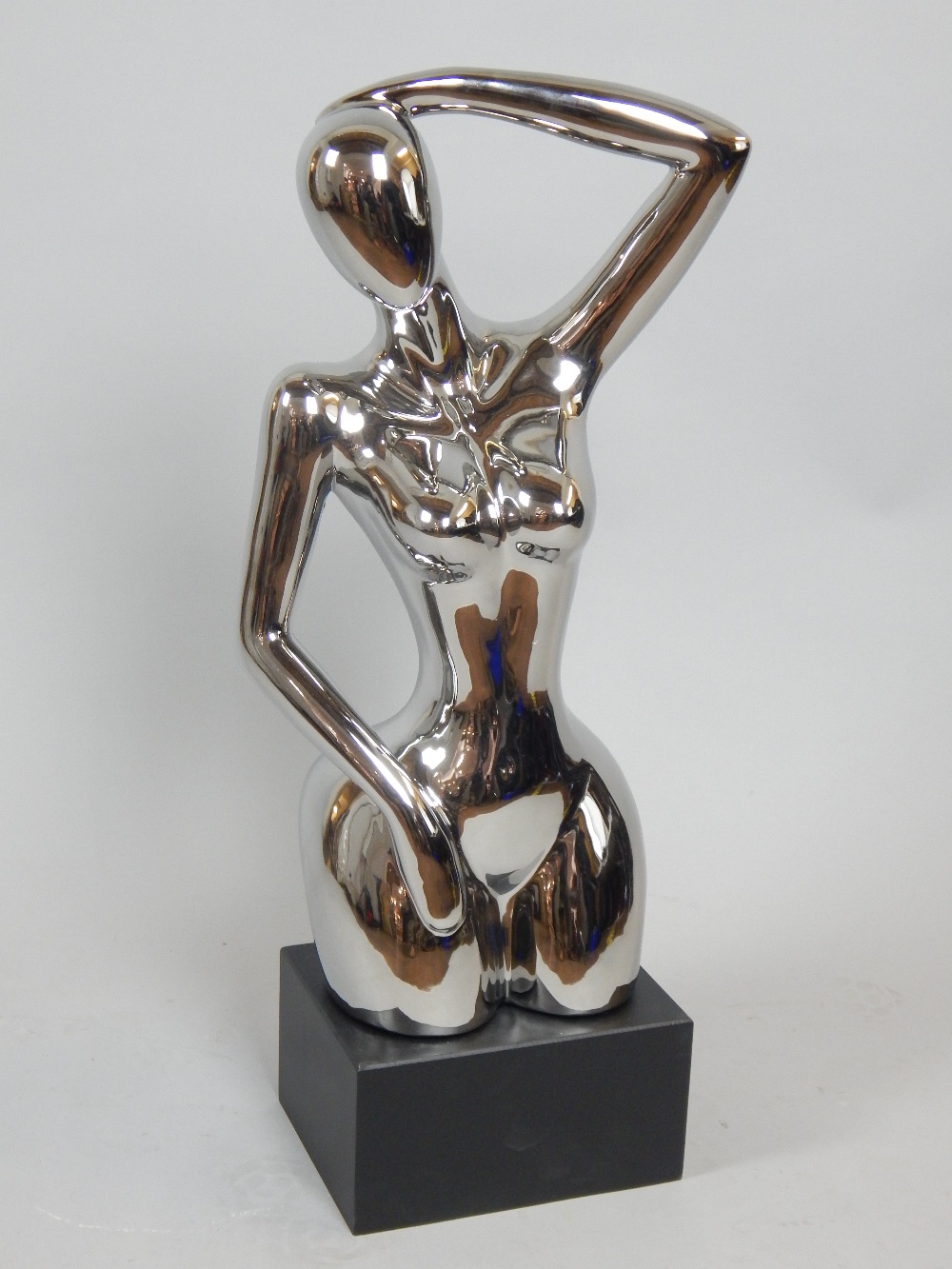 Contemporary silvered ceramic sculpture, female nude on rectangular ebonised plinth, 75cm H.