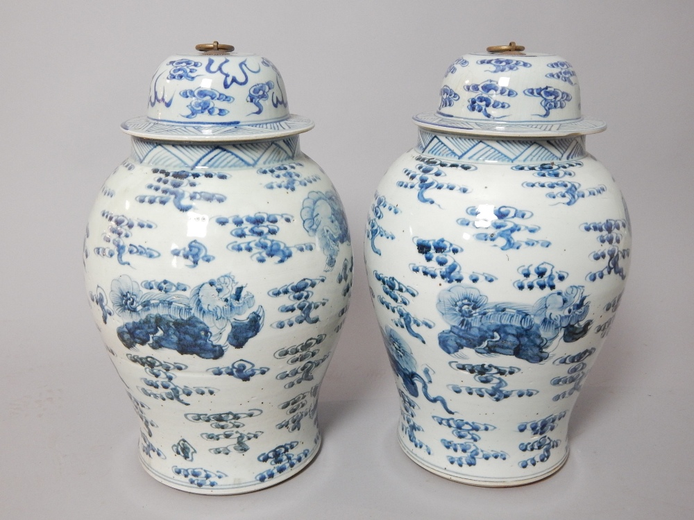 Pair of Chinese blue and white vases with covers, of baluster form and decorated with dragons,