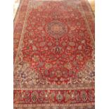 Persian rug, foliate decoration on a red ground within a blue border, 180 x 285cm.