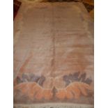 Nepalese woollen rug, pale pink ground within scrolled border over grey edge.