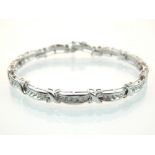9ct white gold diamond bracelet with curved channel set links, total weight 2ct.
