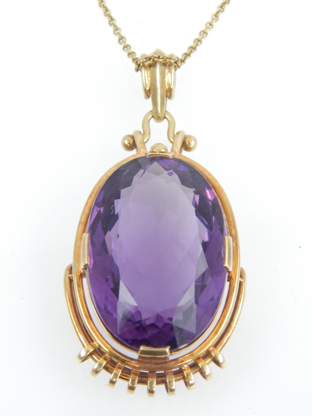 Amethyst pendant, the oval cut stone within a yellow metal frame, on a 14ct gold chain, 17.
