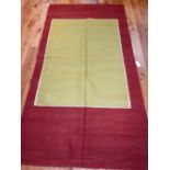 Kelim rug, olive ground within white and red border, 256 x 140cm.