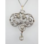 An antique Art Nouveau diamond pendant in yellow gold on a silver chain,