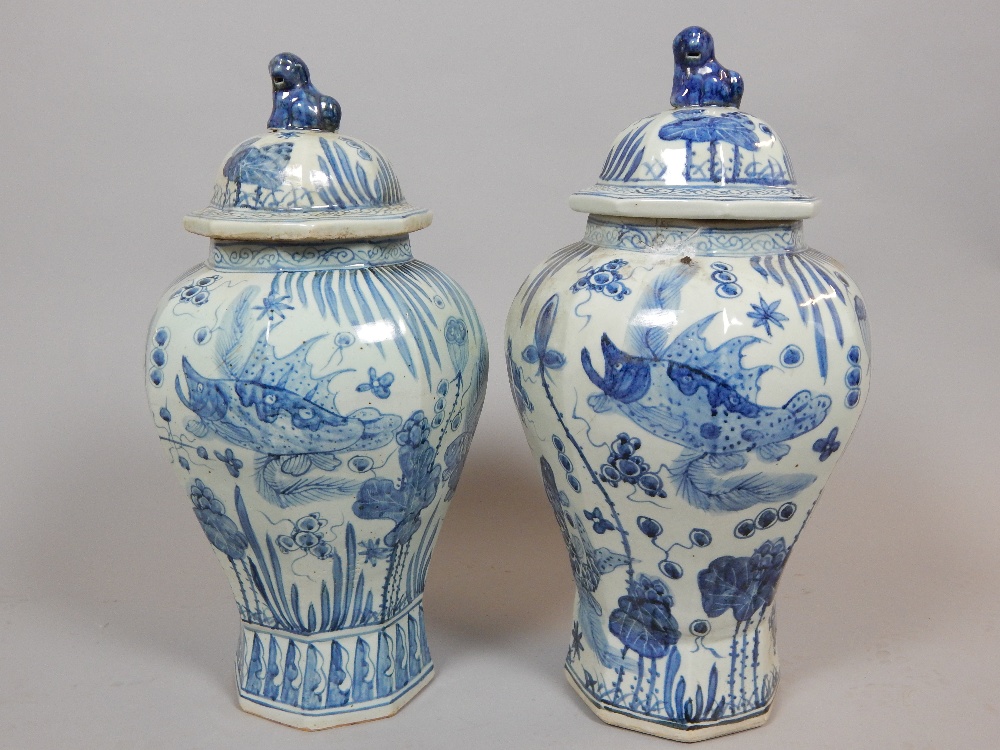 Pair of Chinese octagonal baluster shaped lidded vases, decorated with fish, 57cm h,