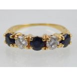 A five stone diamond and sapphire ring in 18ct yellow gold,