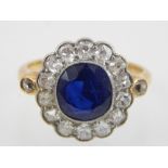 Sapphire dress ring, the central stone within a band of diamonds with diamond set shoulders,