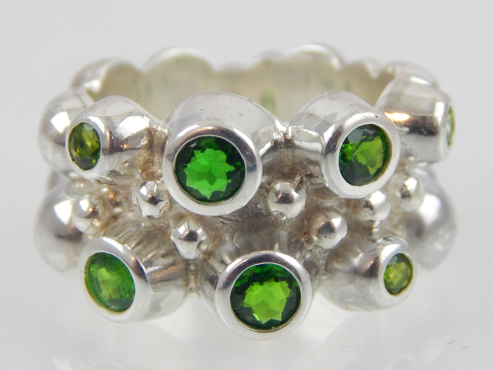 Contemporary silver and diopside ring set with seven collet stones