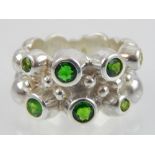 Contemporary silver and diopside ring set with seven collet stones