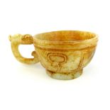 A Chinese carved pale celadon jade dragon handled cup, with ochre markings, 6 x 8cm dia. (14cm