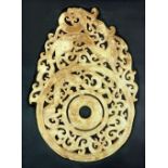 A fine Chinese Han style carved dragon pi roundel in pale green, white and ochre stained jade (