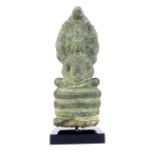 A South East Asian antique bronze group of a deity sitting in the lotus position on a cobra