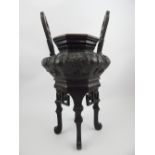 Oriental bronze Koro, early 20th C, octagonal pot with dragon decoration set on shaped box legs,