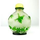 A Peking cameo green over grey glass snuff bottle decorated with butterflies, 8cm high.