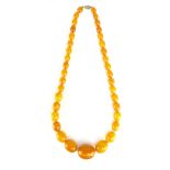 An antique natural amber bead necklace the single string of oval polished beads of varying sizes up