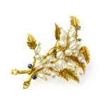 A cultured pearl and sapphire brooch set in high carat gold and naturalistically modeled as a spray