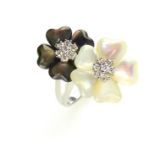A mother of pearl and diamond flower ring set in 18ct white gold, with two diamond clusters,