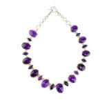 A large amethyst riviere style necklace set in sterling silver with twenty one alternating oval and