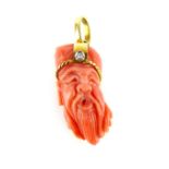 A figural antique coral pendant mounted in 18ct yellow gold and set with a single round brilliant