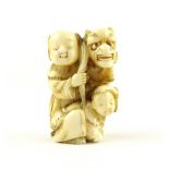 An antique Meiji period Japanese carved ivory netsuke depicting a gentleman and young boy with