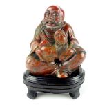 Chinese soapstone figurine of seated Buddha, raised on wooden stand, 14cm h