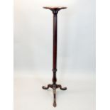 A George III mahogany torchere stand with circular dished top on gunbarrel stem and baluster base