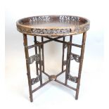 A Chinese padouk wood circular tray top table with carved and pierced gallery, and on a hinged ''