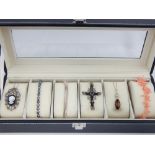 Faux leather jewellery case containing a pink coral necklace with gold clasp, a silver and onyx