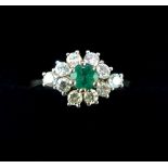 Emerald and diamond set dress ring, the central stone set above a field of smaller claw set gems,