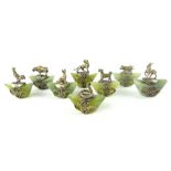 Set of eight Chinese white metal mounted green hardstone cloth weights cast with various animals and