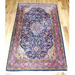 Persian Keshan rug, foliate decoration to centre and border over indigo and red ground,