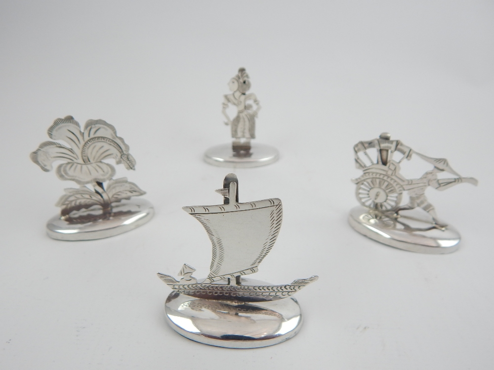 Set of four Eastern themed sterling silver menu holders.