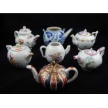 Six Victoria & Albert edition reproduction porcelain tea pots and a Chinese blue and white teapot.