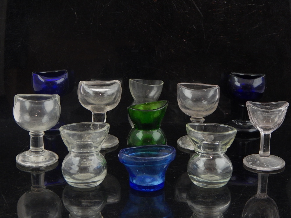 Eleven late 19th and early 20th century various clear and blue glass eye baths.