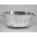 Large silver plated champagne bath, of oval form with twin handles and a gadrooned rim and base,